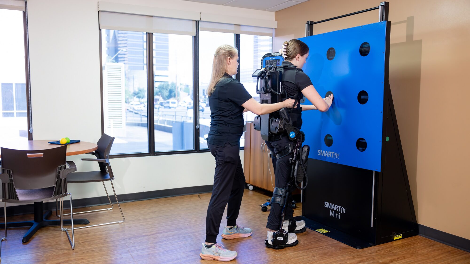 Barrow Neuro-Rehab patient completes a SMARTfit exercise with the help of her physical therapist.