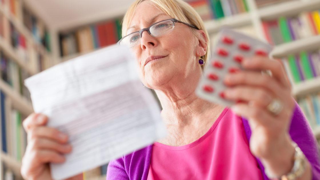 A woman looks at her medication and its instructions.