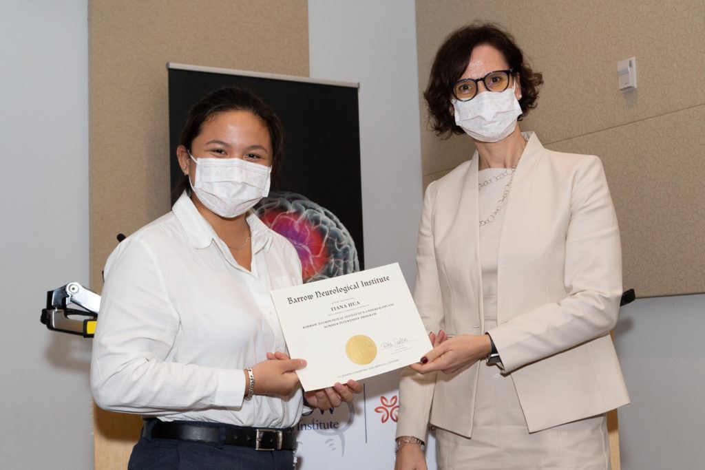 Tiana Hua holding a completion certificate and standing next to Dr. Rita Sattler