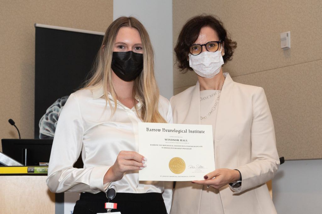 Windsor Hall holding a completion certificate and standing next to Dr. Rita Sattler