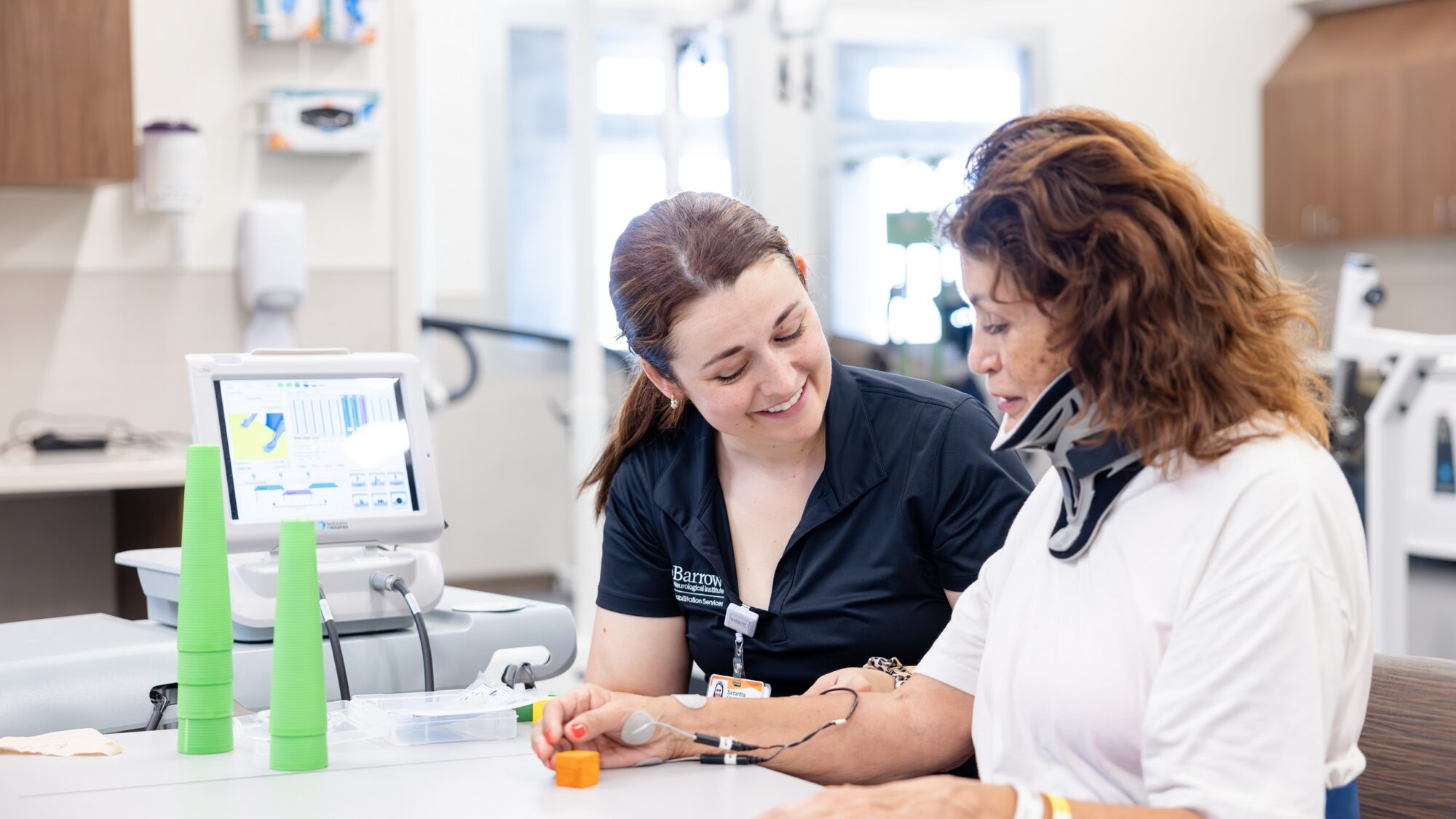 Barrow Neuro-Rehab patient using the xcite system with the help of her therapist.