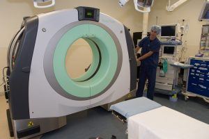 photograph of a radiology technician positioning a body tom portable CT scanner in preparation for spine surgery at Barrow Neurological Institute