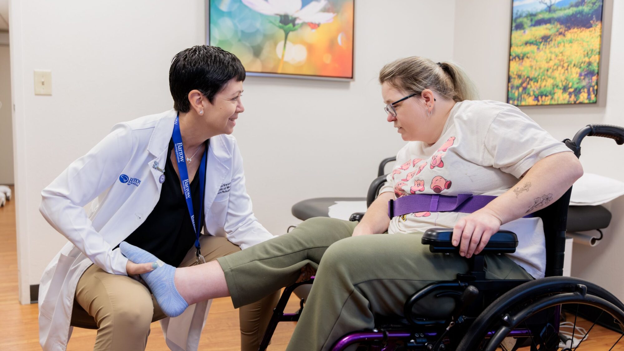 Dr. Christina Kwasnica treating a neuro-rehabilitation a patient in an exam room.