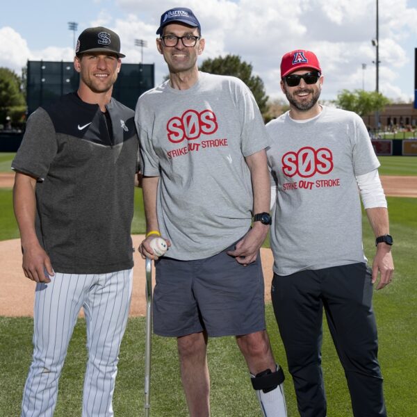 dave allen stands on a baseball field holding a baseball at the strike out stroke event