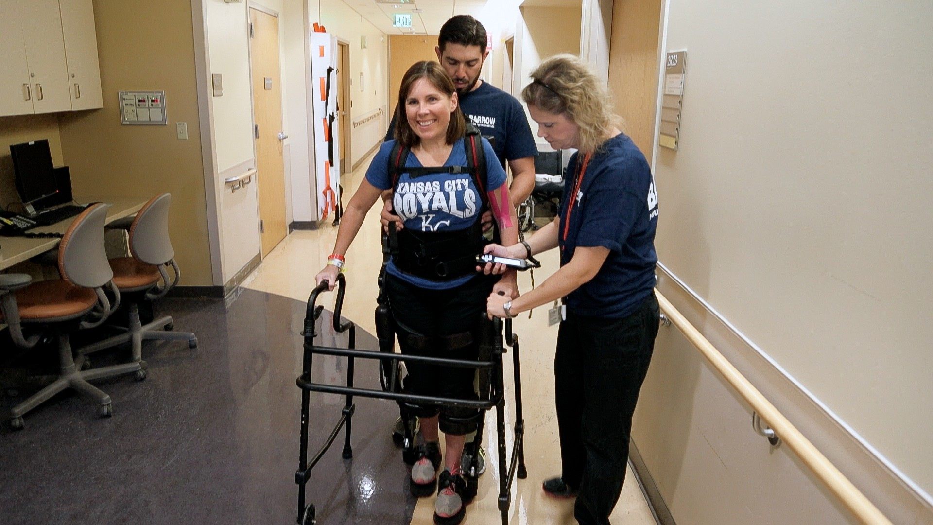 Healthcare workers helping a patient with exoskeleton therapy