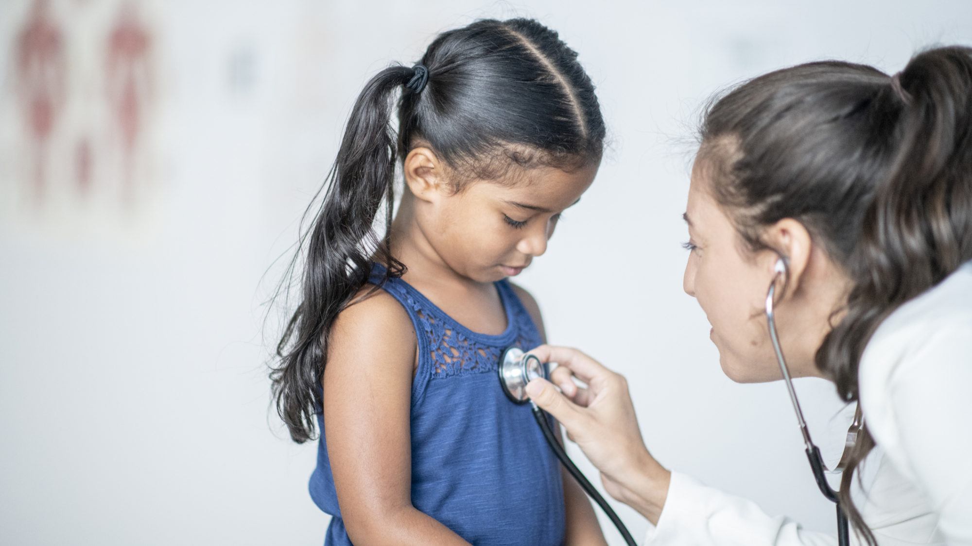 pediatrician using stethoscope on patient