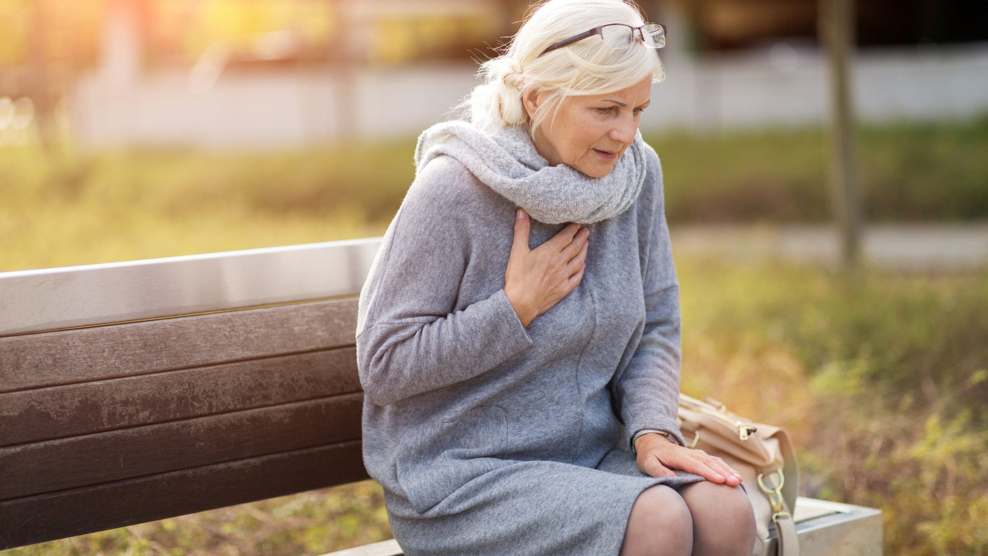 senior woman with her hand on her chest in pain