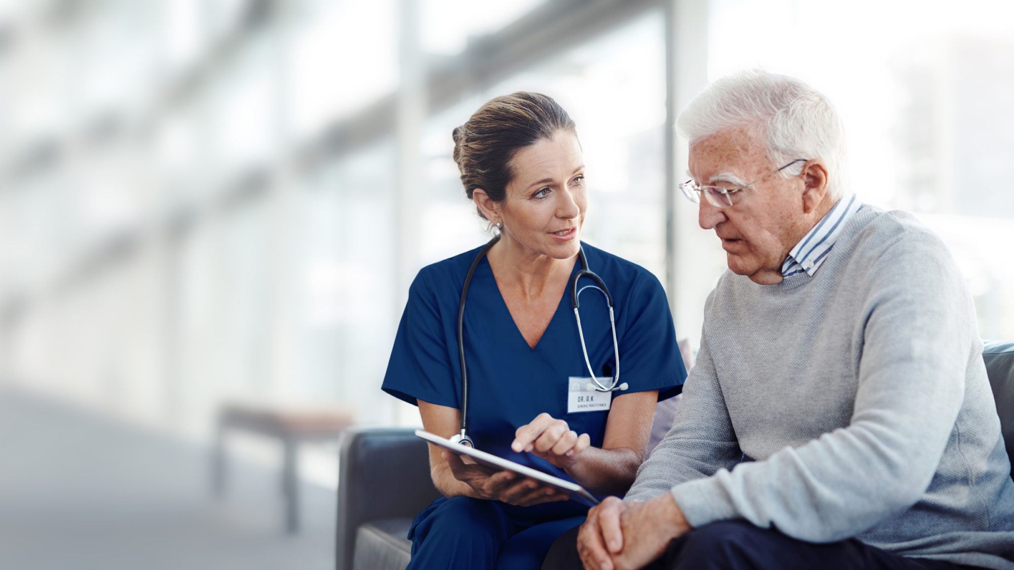 Nurse showing senior patient something on tablet