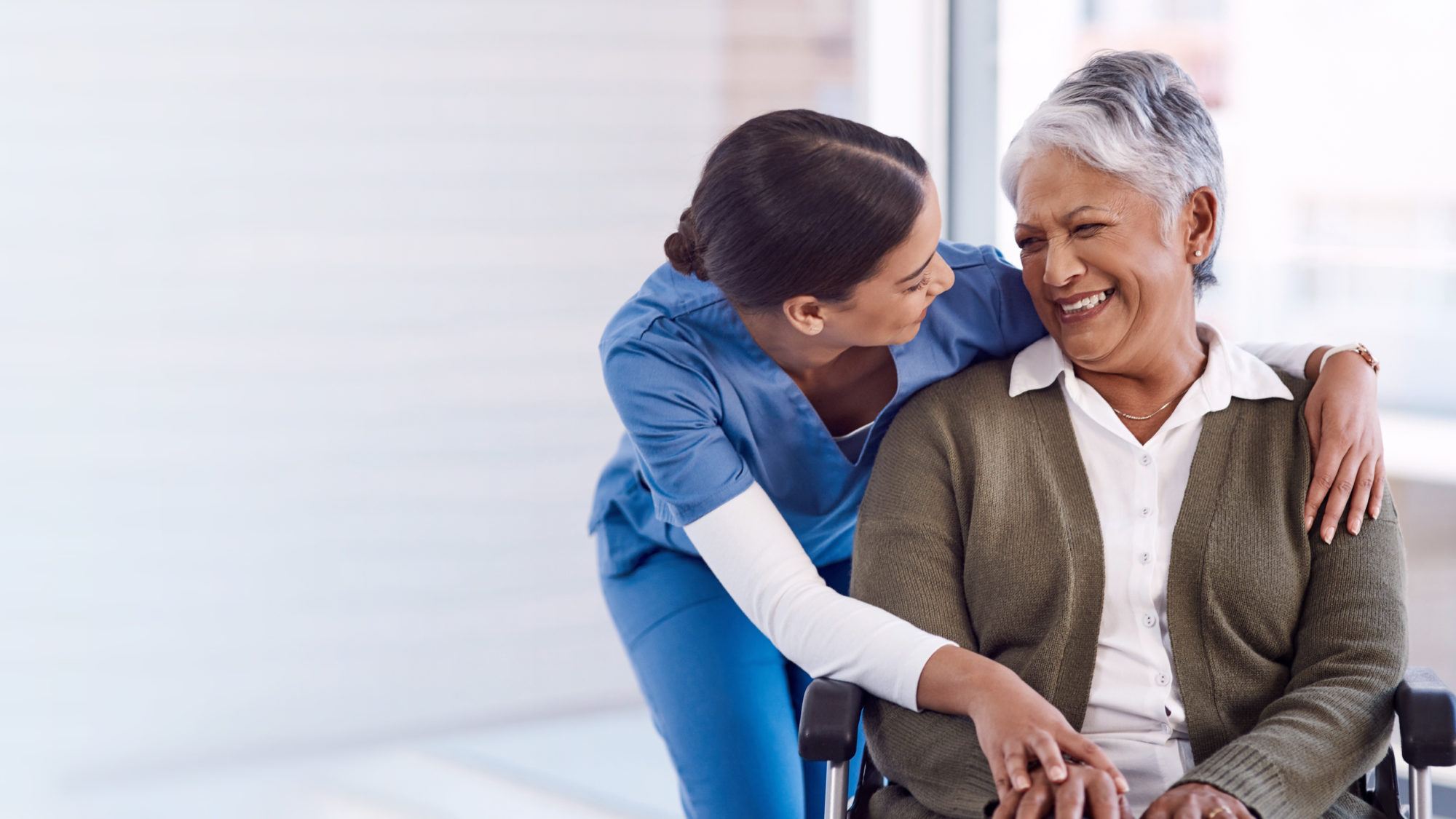 Nurse caring for senior woman in wheelchair