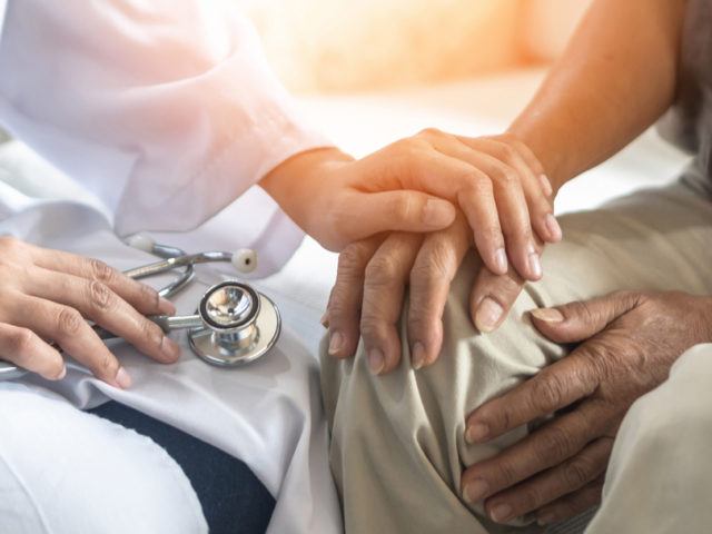 doctor holding senior patient's hand