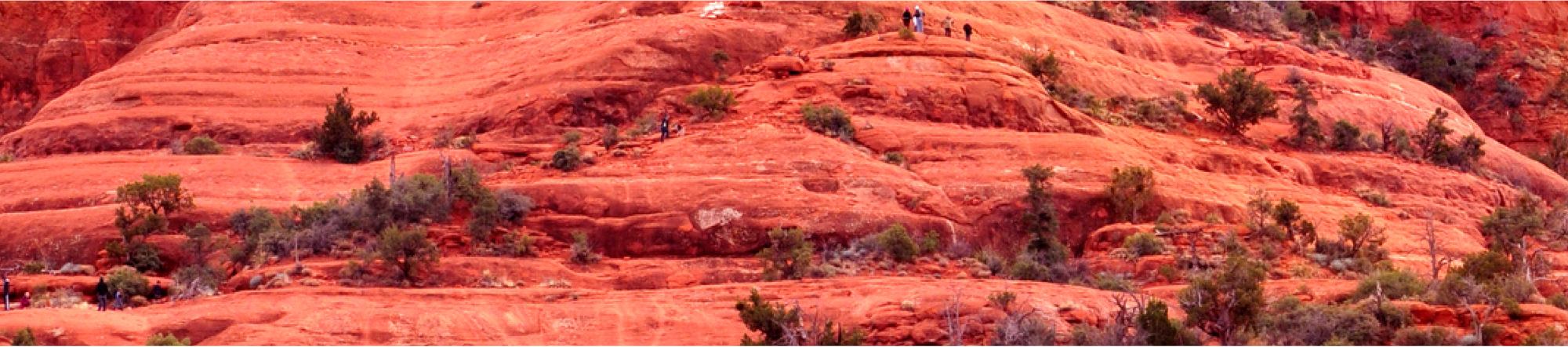 desert rock formations in front of pink and yellow sky