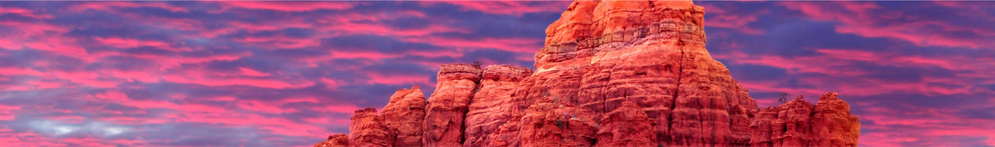 rock formation in front of pink and purple sky