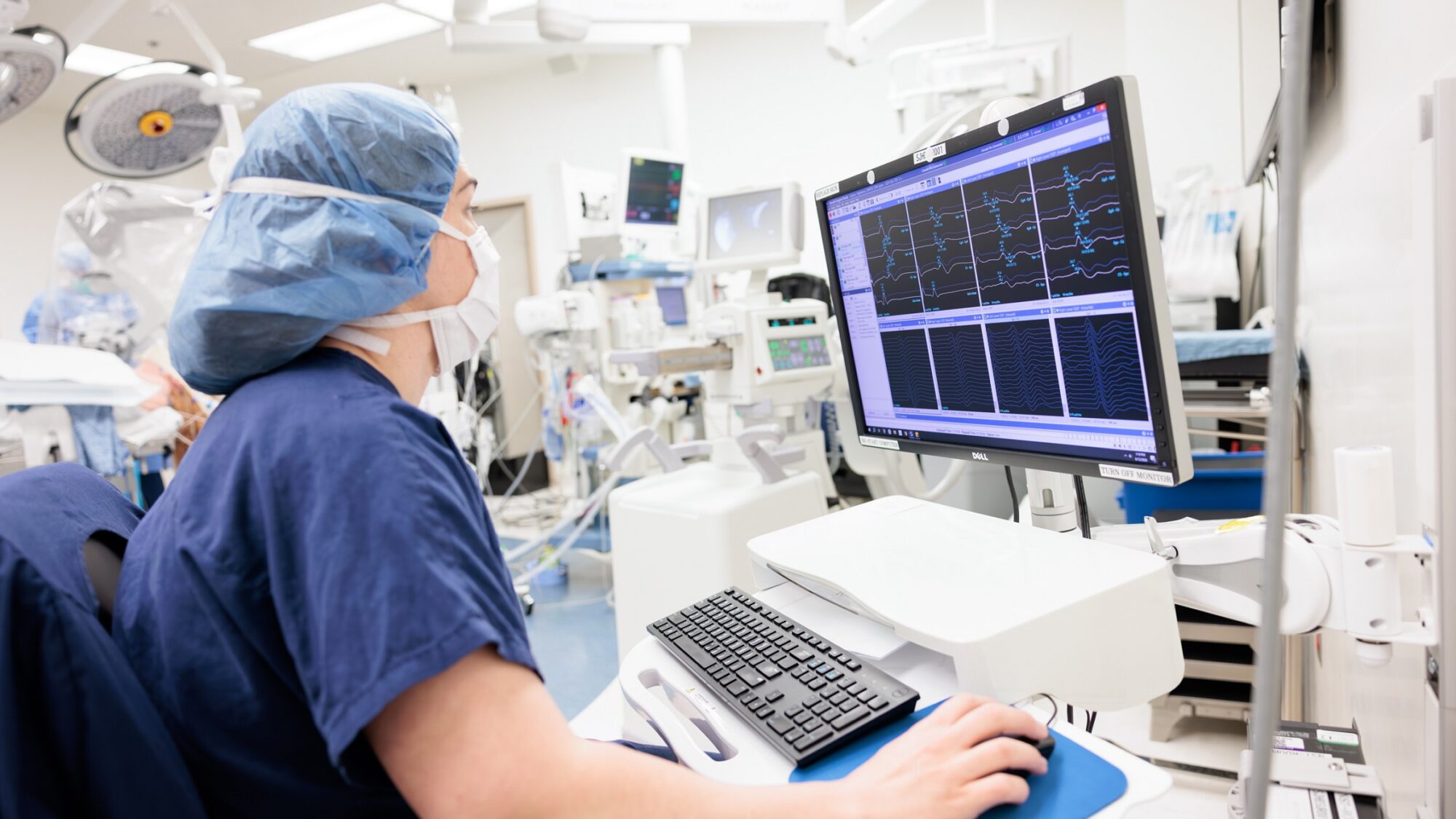 a nurse reviews evoked potentials on a screen in an operating room as part of our intraoperative monitoring service