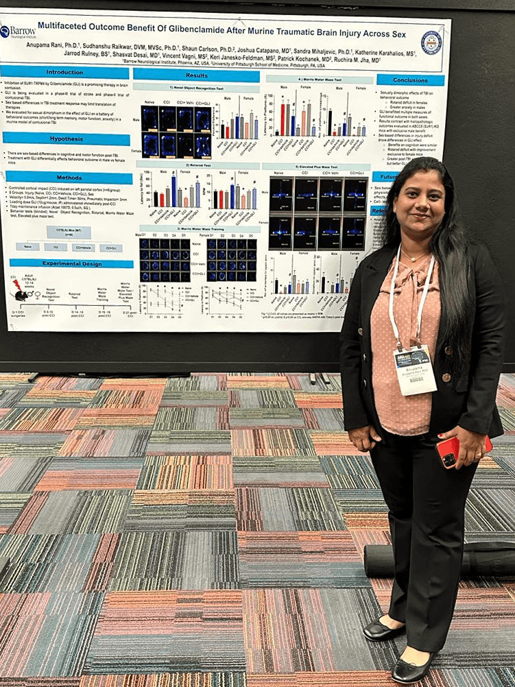 Postdoctoral fellow stands in front of award-winning poster