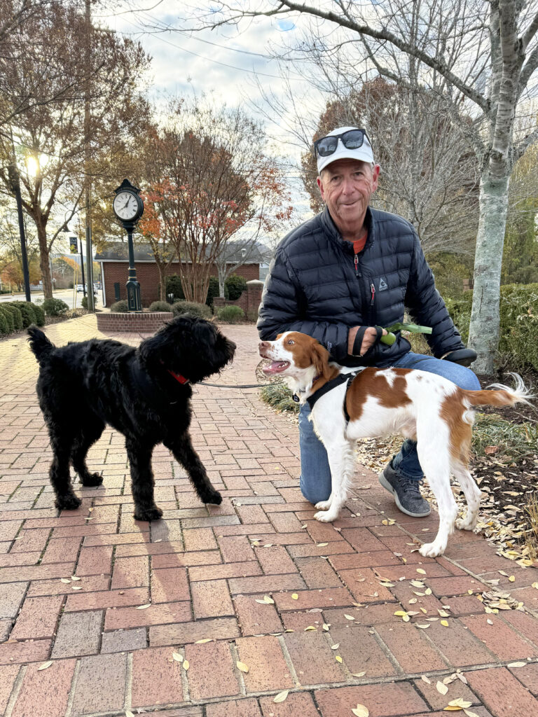 John kneels down for a photo with his granddogs in South Carolina