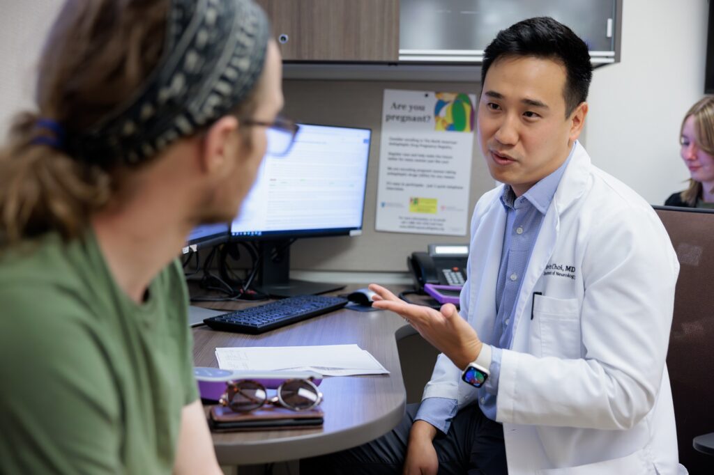 neurologist kevin choi speaks with an epilepsy patient in an exam room