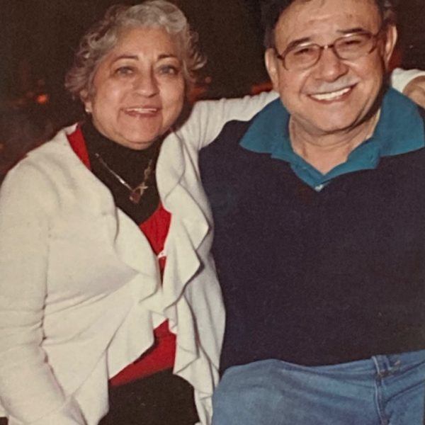 Maricela with her arm around her husband, Juan. The two are seated.