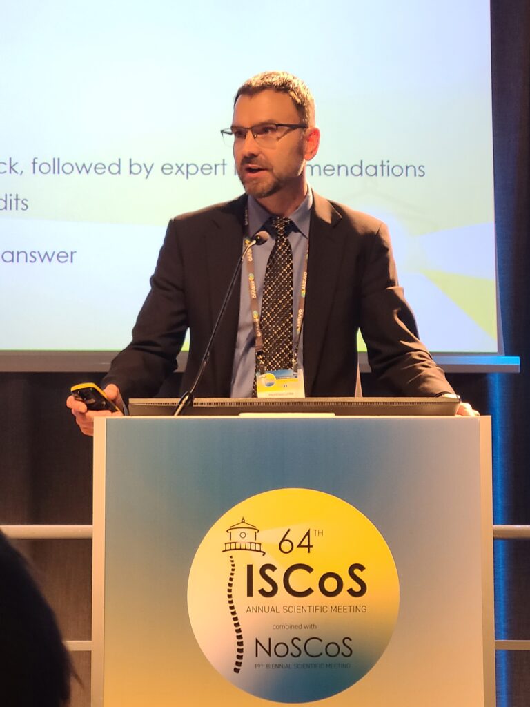 Dr. Matthias Linke stands at the podium at the ISCoS meeting to deliver a presentation.