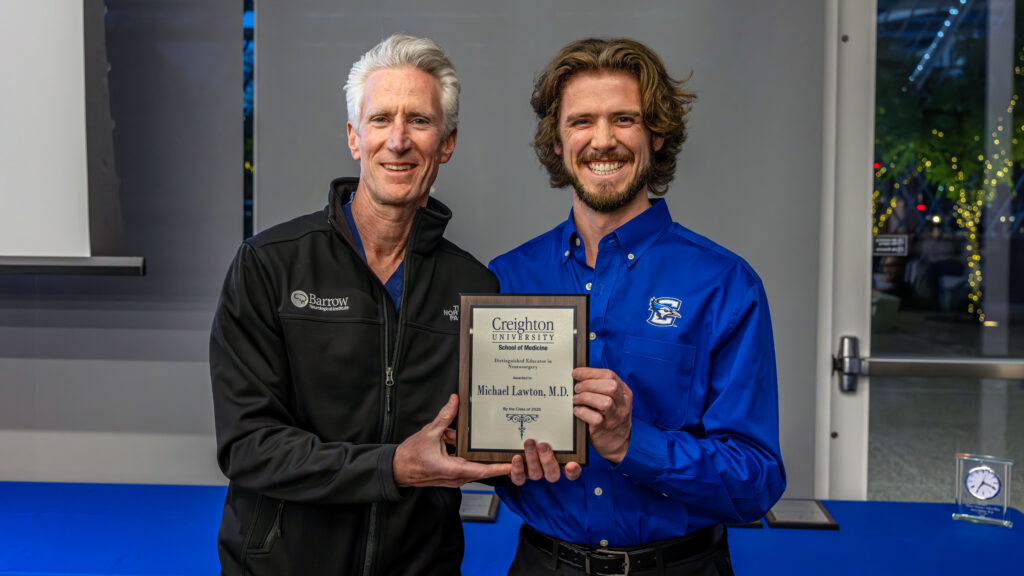 Dr. Lawton photographed with his plaque at the CUSOM award ceremony.