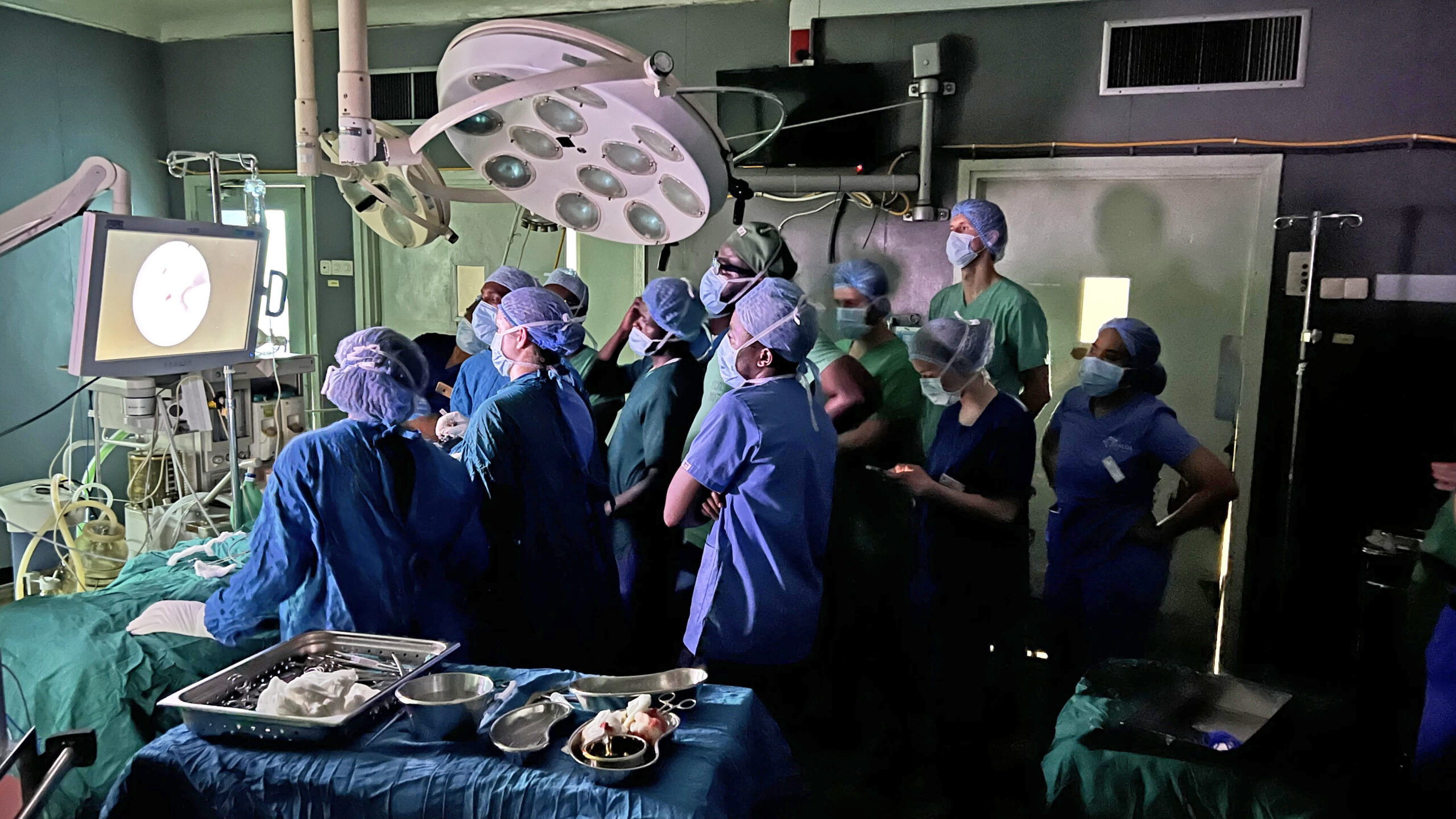 Trainees and surgical staff gather around Barrow neuroanesthesiologist Dr. Brian Wilhelmi in the operating room at Kilimanjaro Christian Medical Centre.