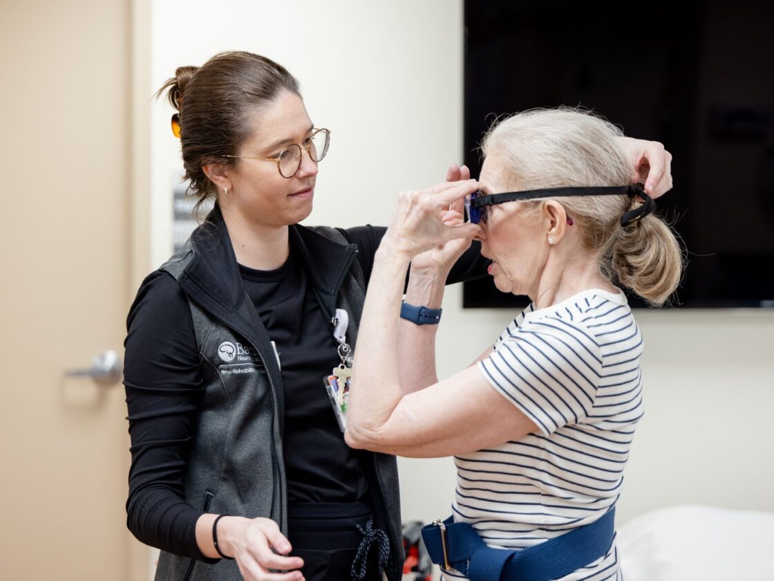 Barrow Neuro-Rehab patient adjusts goggles that alter vision to practice balancing and coordination.