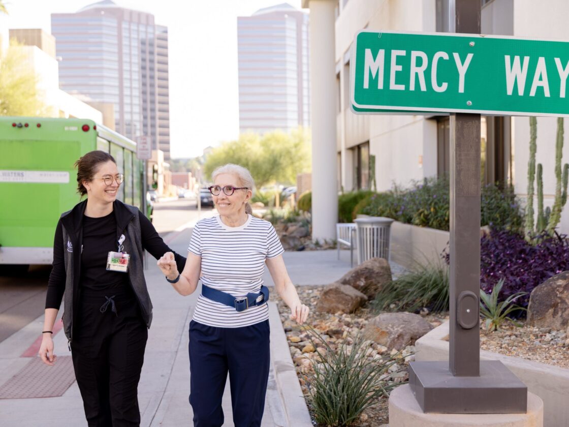 Barrow Neuro-Rehab patient walks outside with therapist.