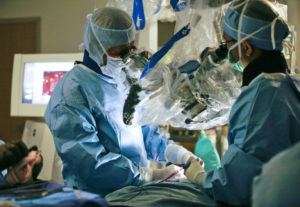 Dr. Volker Sonntag in the operating room with a microscope