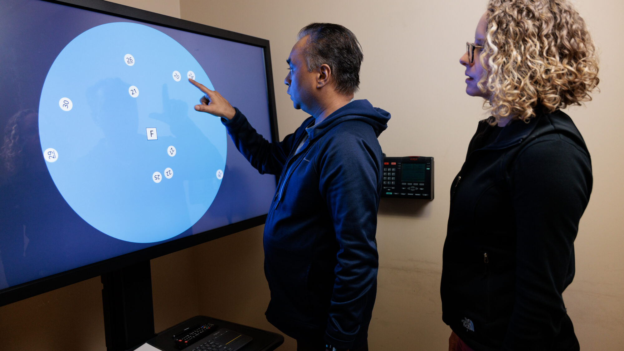 Transitional Neuro-Rehab patient selecting numbers on a screen for an exercise.