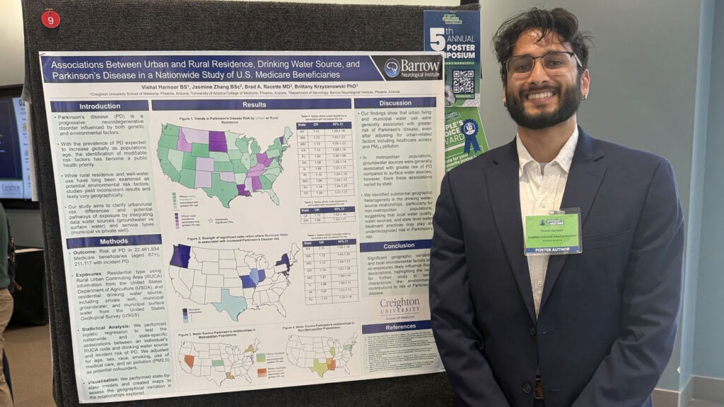 Vishal Harnoor stands next to his award-winning poster