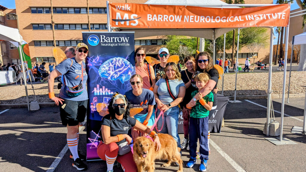 The Barrow team attends Walk MS, posing for a photo underneath a pop-up tent that says "Barrow Neurological Institute"
